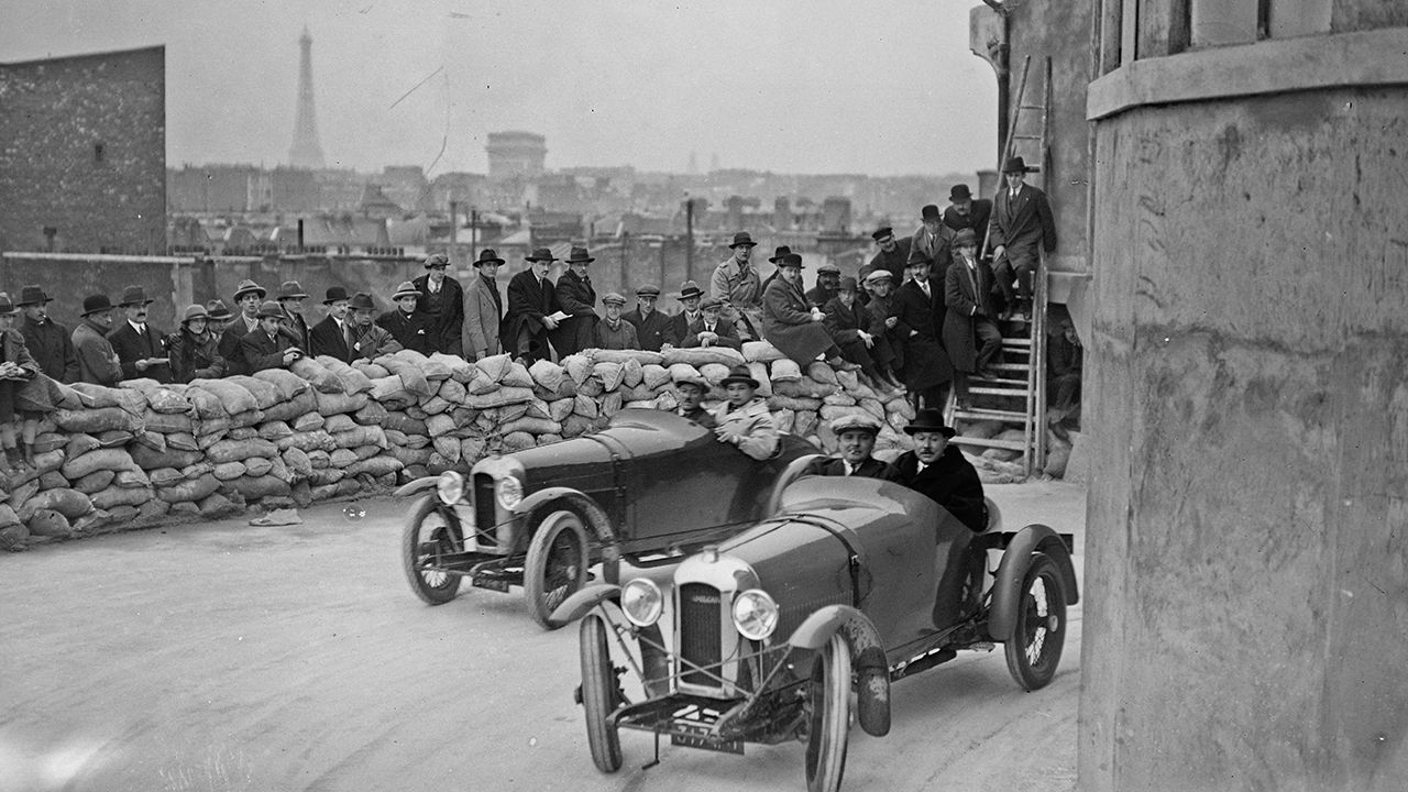 Albert Divo con René Thomas en primer plano y André Morel, ambos con Amilcar, disputando una carrera simulada