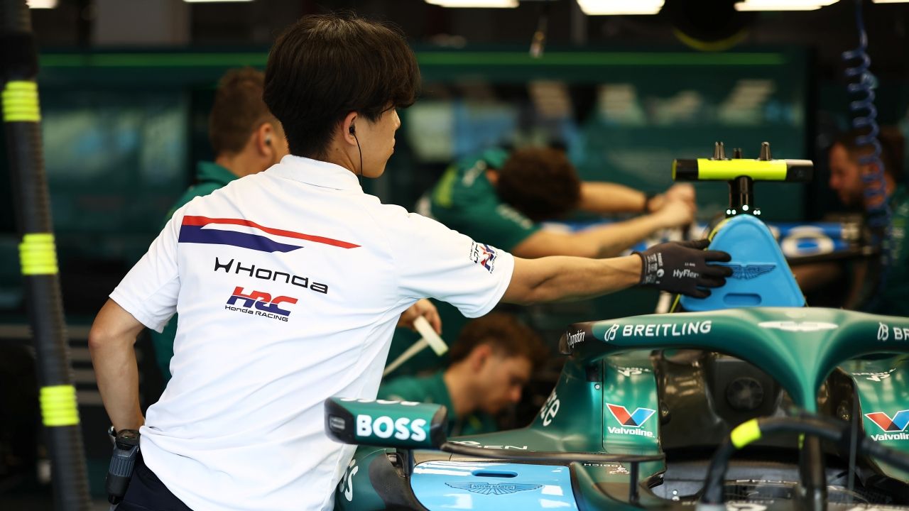 Ingeniero de Honda trabaja en un monoplaza de Aston Martin F1 en el garaje de un circuito.