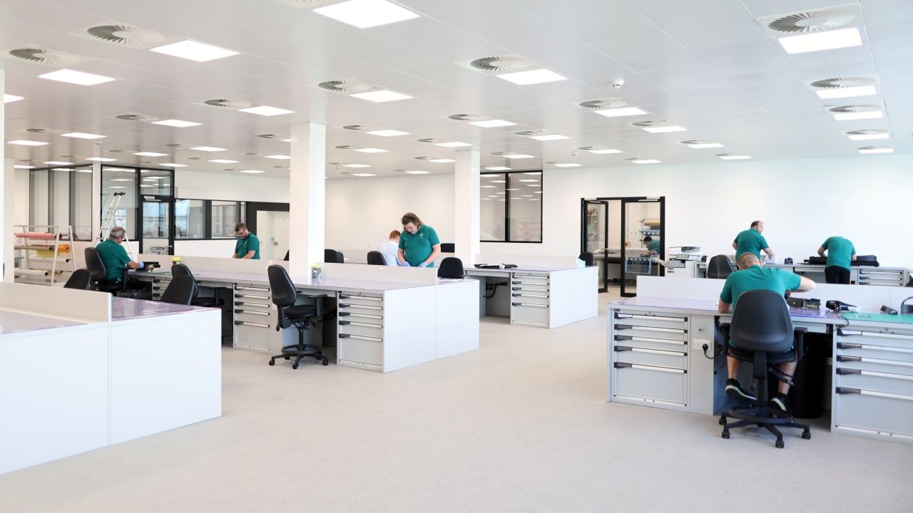 Miembros de Aston Martin F1 trabajan en una sala compartida.