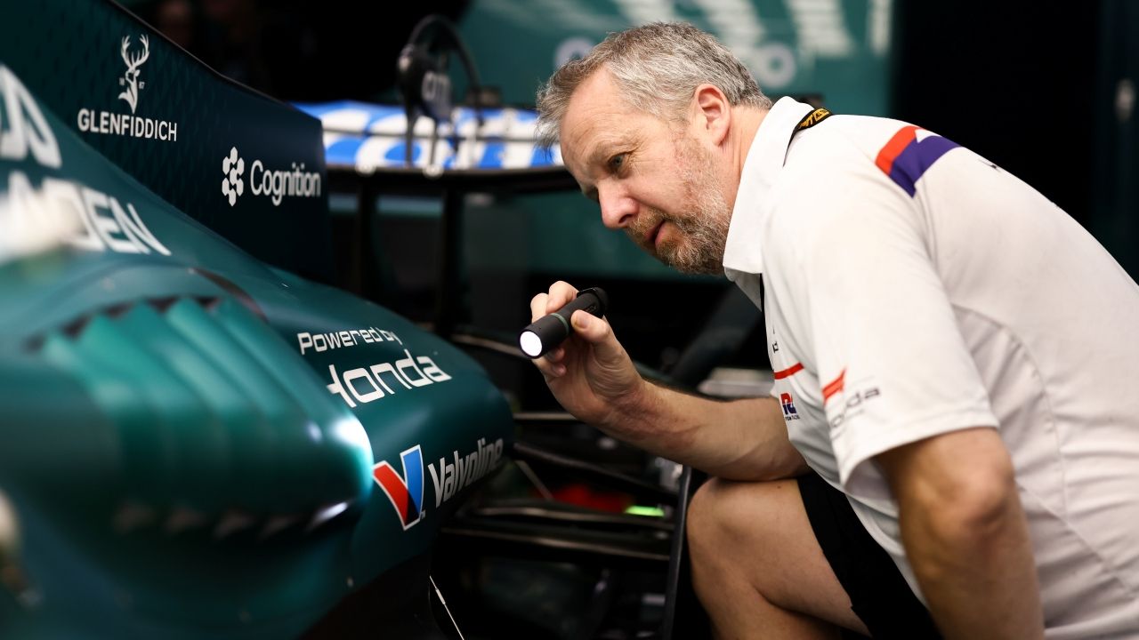 Un ingeniero de Honda examina el interior del Aston Martin AMR26 con una linterna.