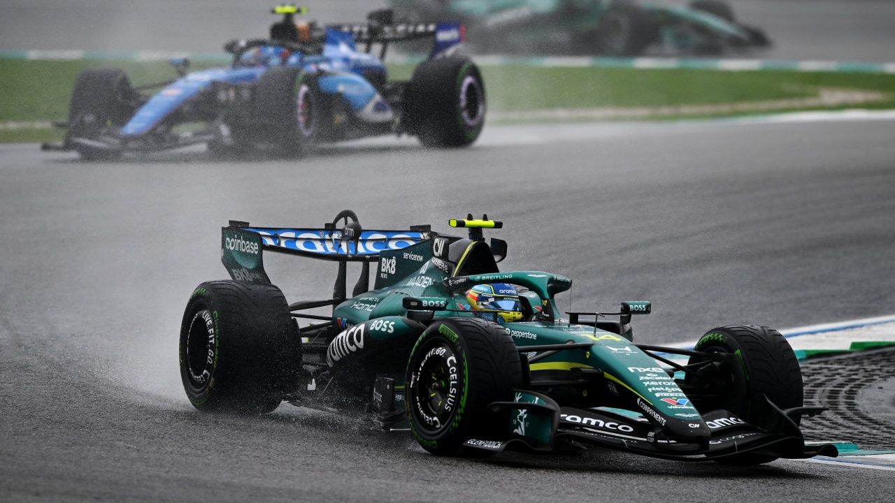 Un Aston Martin de F1 conducido por Fernando Alonso rueda sobre asfalto mojado en el circuito de Sepang.
