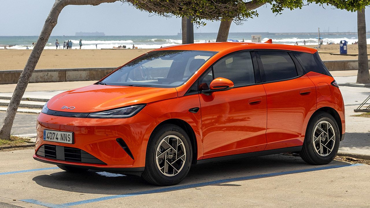 BYD Dolphin G DM-i en color Orange Sunset estacionado junto a la playa