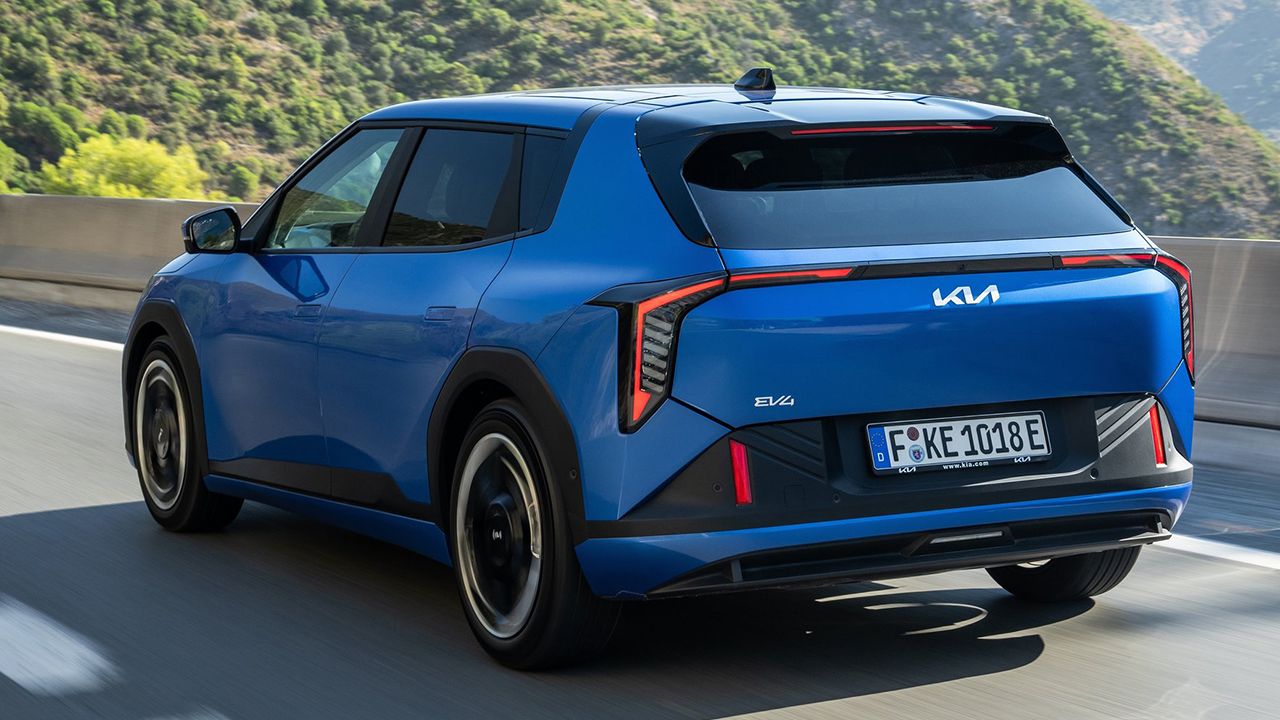 Vista lateral trasera del KIA EV4 en azul circulando por carretera