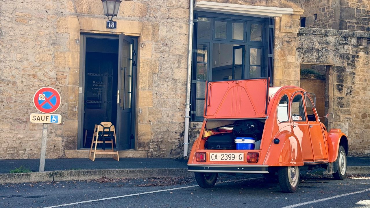 Citroën 2CV naranja con el portón del maletero abierto.