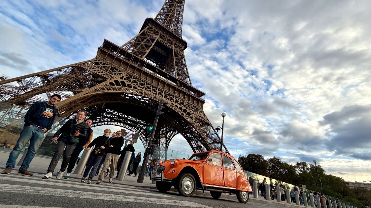 Un Citroën 2CV naranja a los pies de la Torre Eiffel.