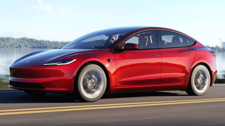 Un Tesla Model 3 rojo en movimiento.