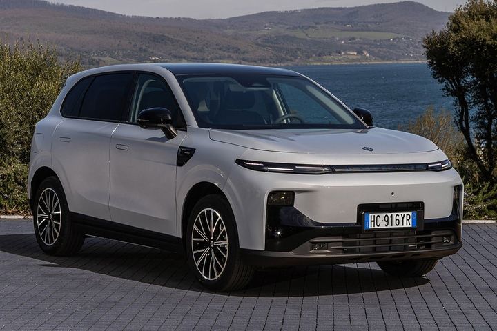 Leapmotor B10 gris en tres cuartos delantero, aparcado en exterior junto a un lago.
